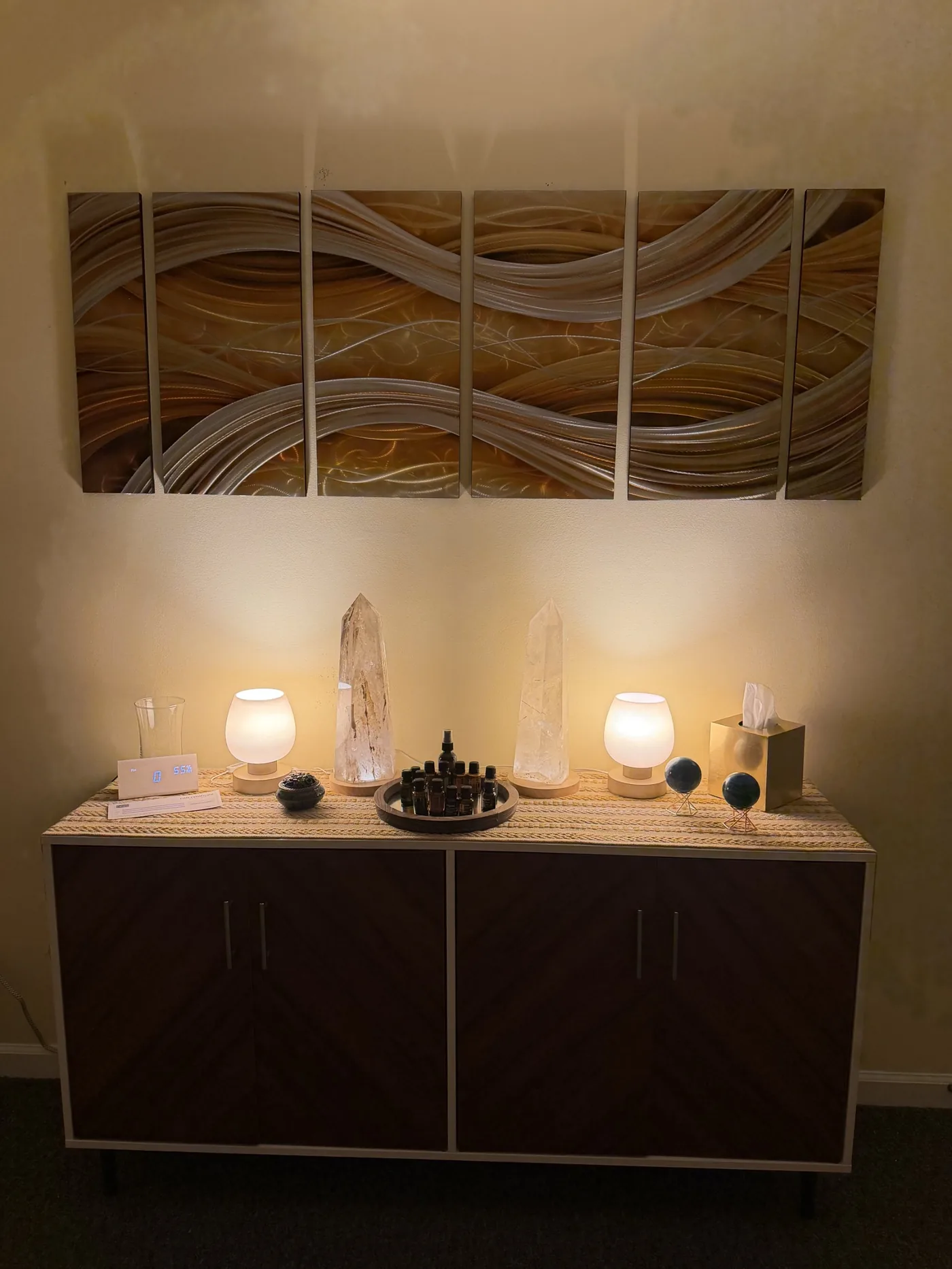 Crystals, oils, and soft lamps on the credenza