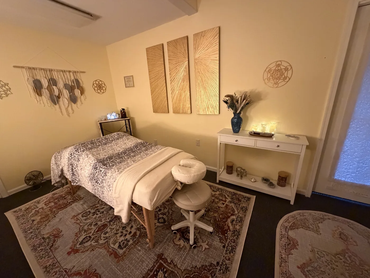 Massage table beneath three gold sunburst panels