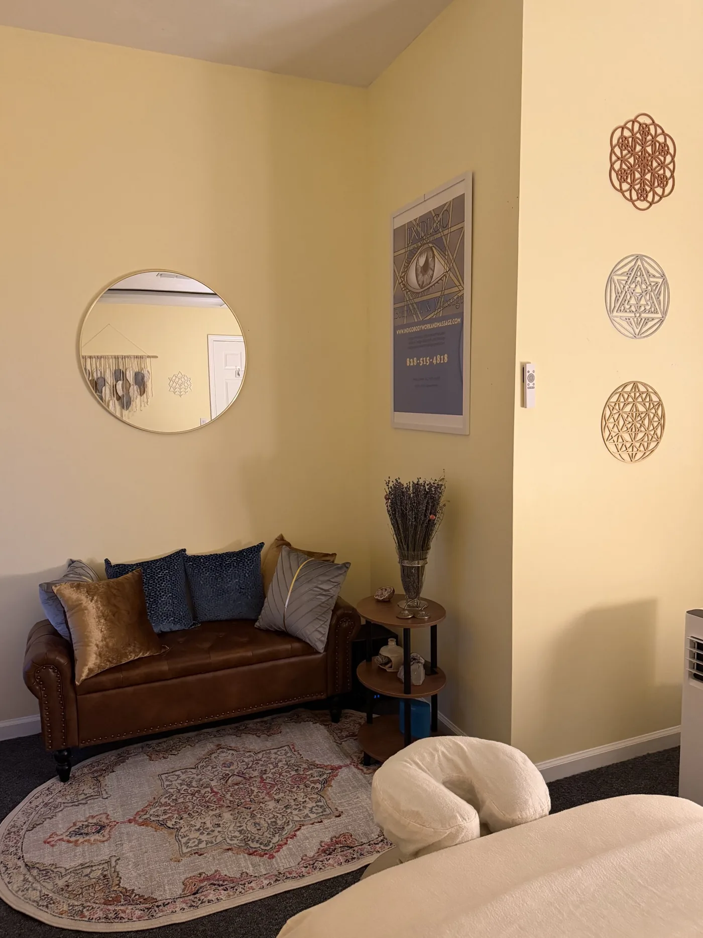 Leather settee beneath the Indigo poster and sacred geometry wall art